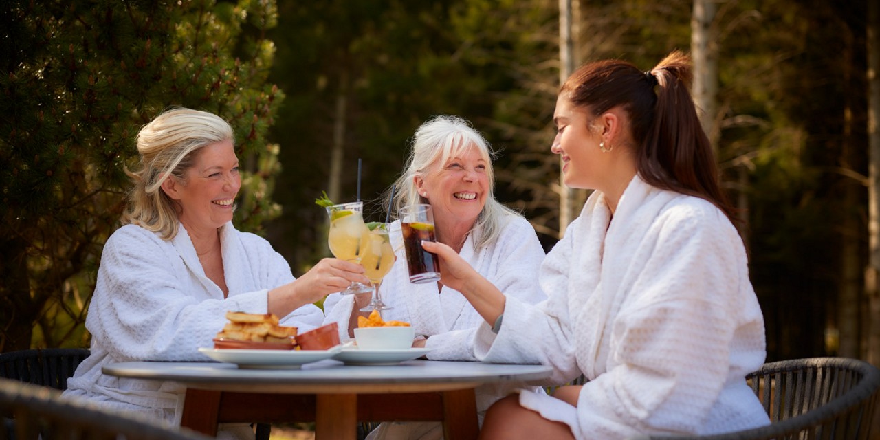 two women drinking prosecco on outdoor terrace 