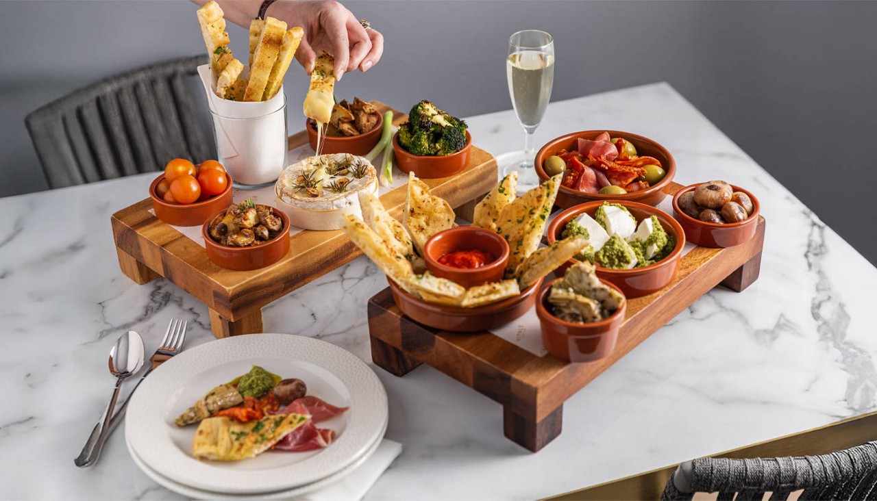 Sharing platter with dips and flaatbreads.